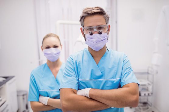 dentist standing with arms crossed dental clinic